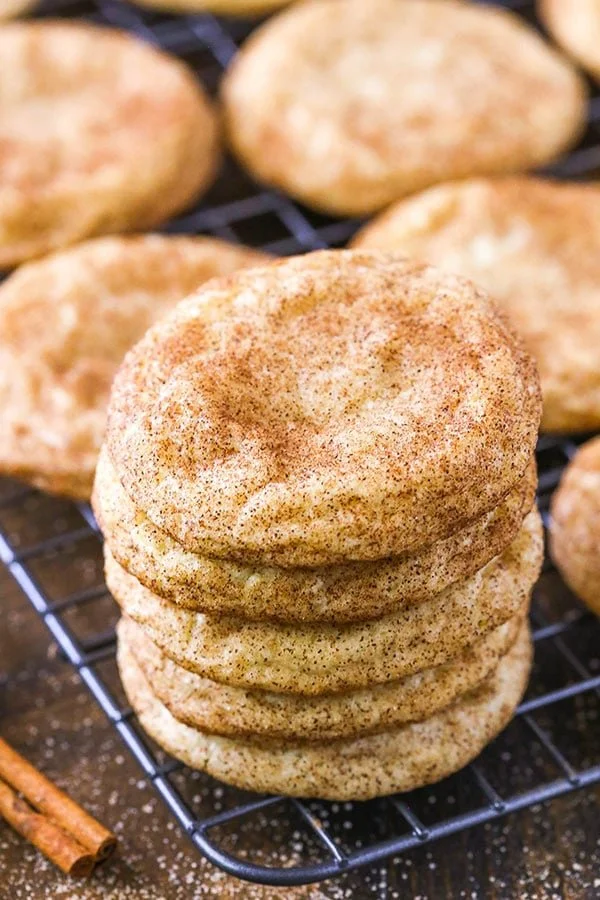 Freshly baked snickerdoodle cookies on a cooling rack, dusted with cinnamon sugar.