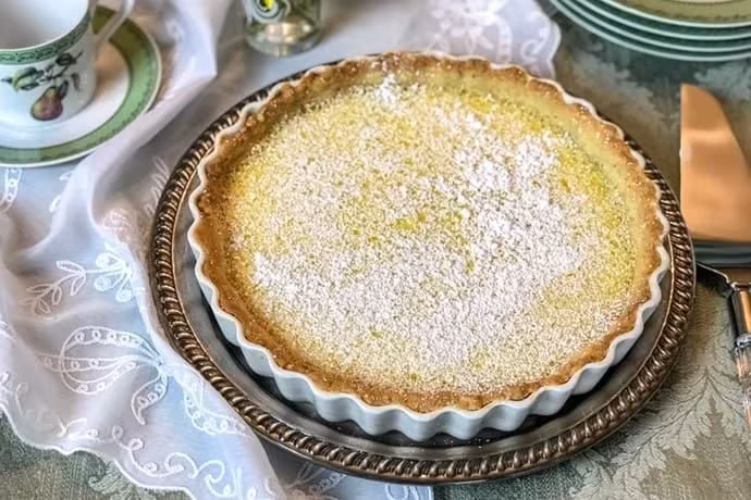 Delicious lemon tart with a shortbread base, garnished with fresh lemon slices.