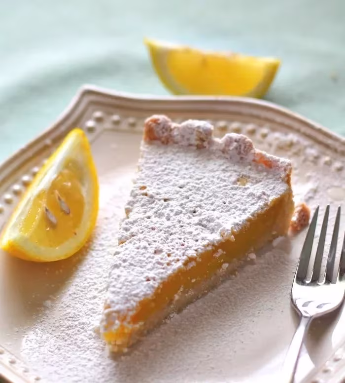 Delicious lemon tart with a buttery shortbread crust garnished with lemon zest