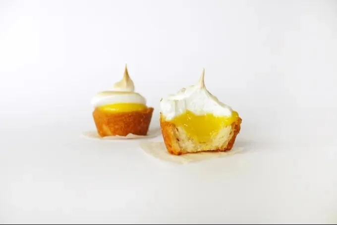 Two-bite lemon meringue pies topped with fluffy meringue and lemon zest.