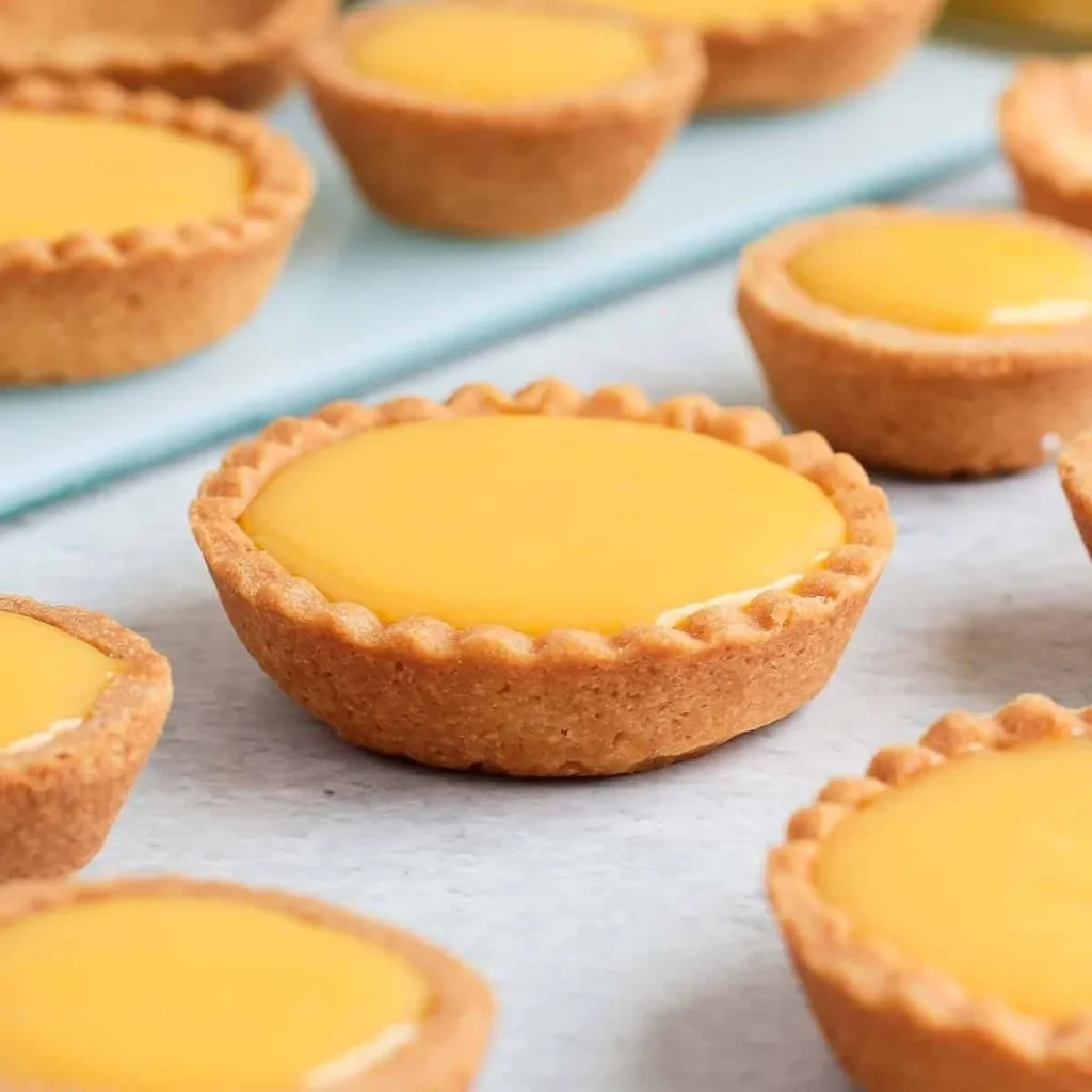 Zesty tartlets topped with creamy lemon curd, perfect for dessert lovers