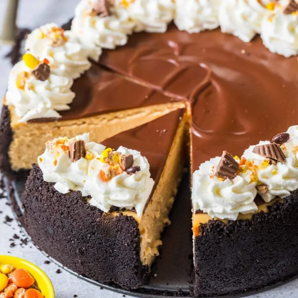 Creamy peanut butter cheesecake topped with whipped cream and peanuts