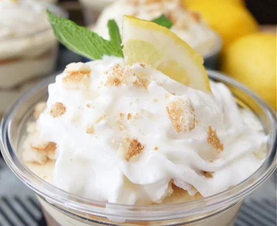 Lemon Pudding Parfait Recipe 4 Delicious lemon pudding parfait served in a glass with fresh lemon slices and whipped cream.