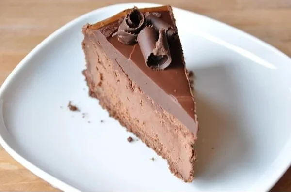Luxurious chocolate cheesecake topped with chocolate shavings and berries