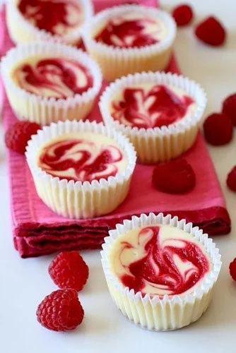 Raspberry swirl cheesecake cupcakes with a creamy topping and raspberry drizzle