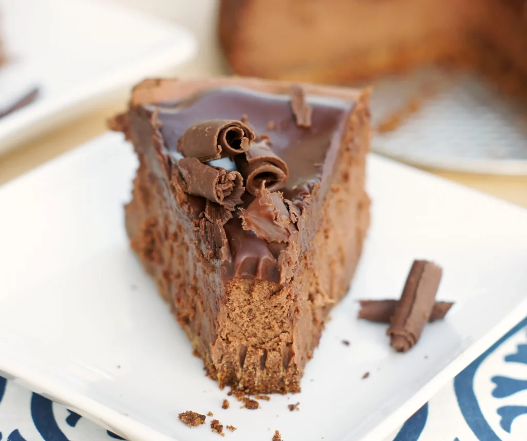 A slice of ultimate decadent chocolate cheesecake topped with chocolate shavings